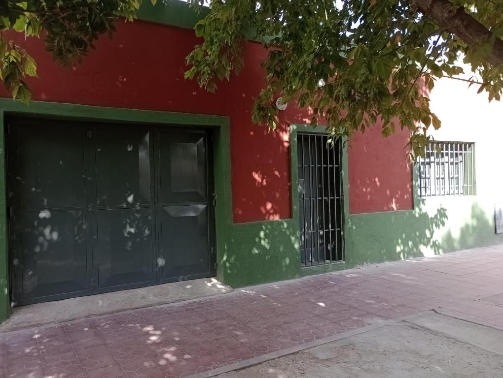 a red and green building with a door at Alojamiento mendoza in Las Heras