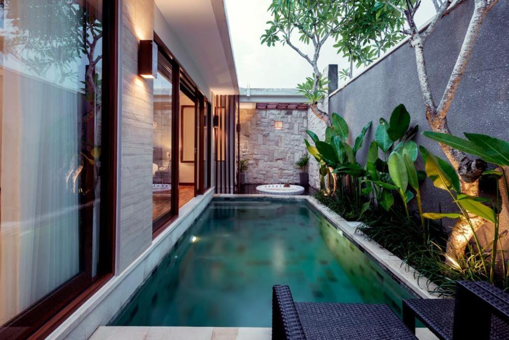 a swimming pool in the middle of a house at Sanata Luxury Villa in Canggu