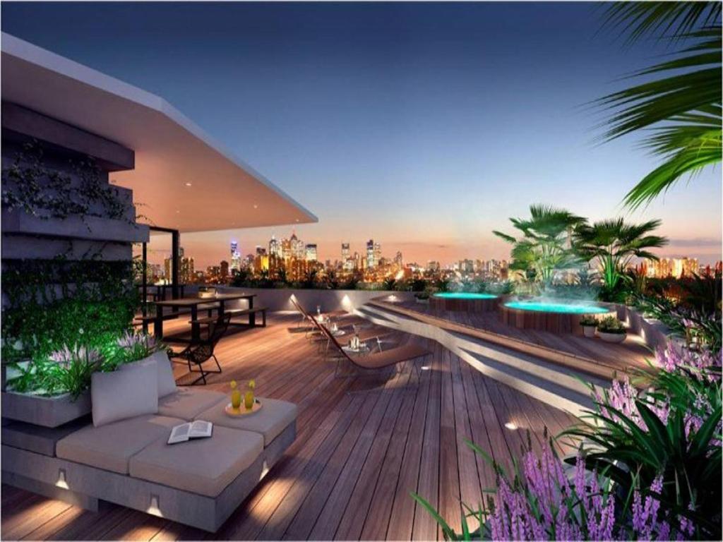a rooftop deck with a view of a city at night at Riverside Resort Apartment in Melbourne