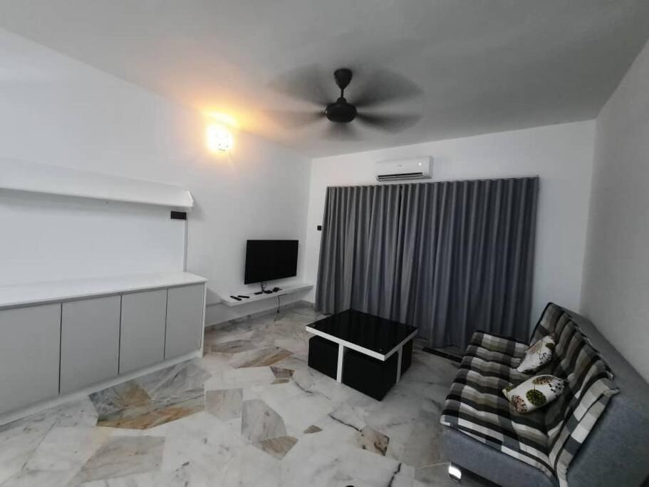 - un salon avec un canapé et un ventilateur de plafond dans l'établissement XHQ Home stay - Bayview b-9-2, à Kampong Baharu
