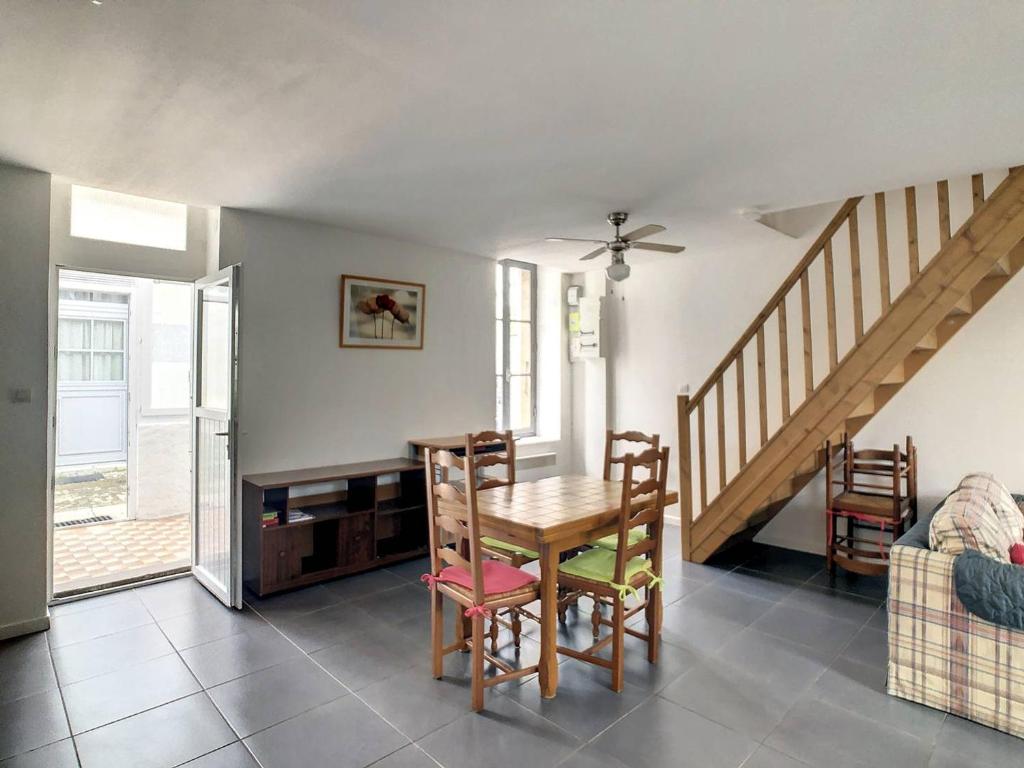 une salle à manger avec une table, des chaises et un escalier dans l'établissement Maison La Rochelle, 3 pièces, 4 personnes - FR-1-710-15, à La Rochelle