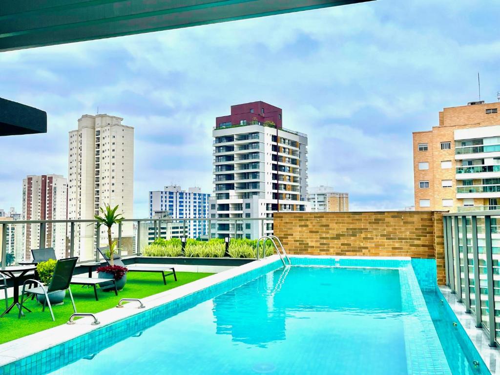 a swimming pool on the roof of a building at Cozzy Suites Paraíso Hotel in Sao Paulo
