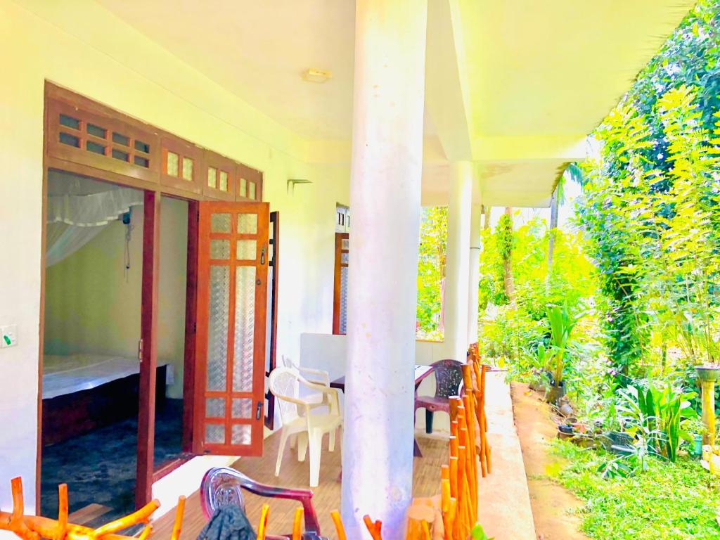 a porch of a house with a table and chairs at Green Horizon Ella in Ella