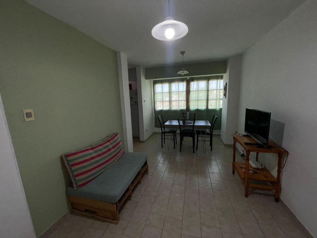 sala de estar con TV y mesa con sillas en Departamento Pascual Toso en Villa Nueva