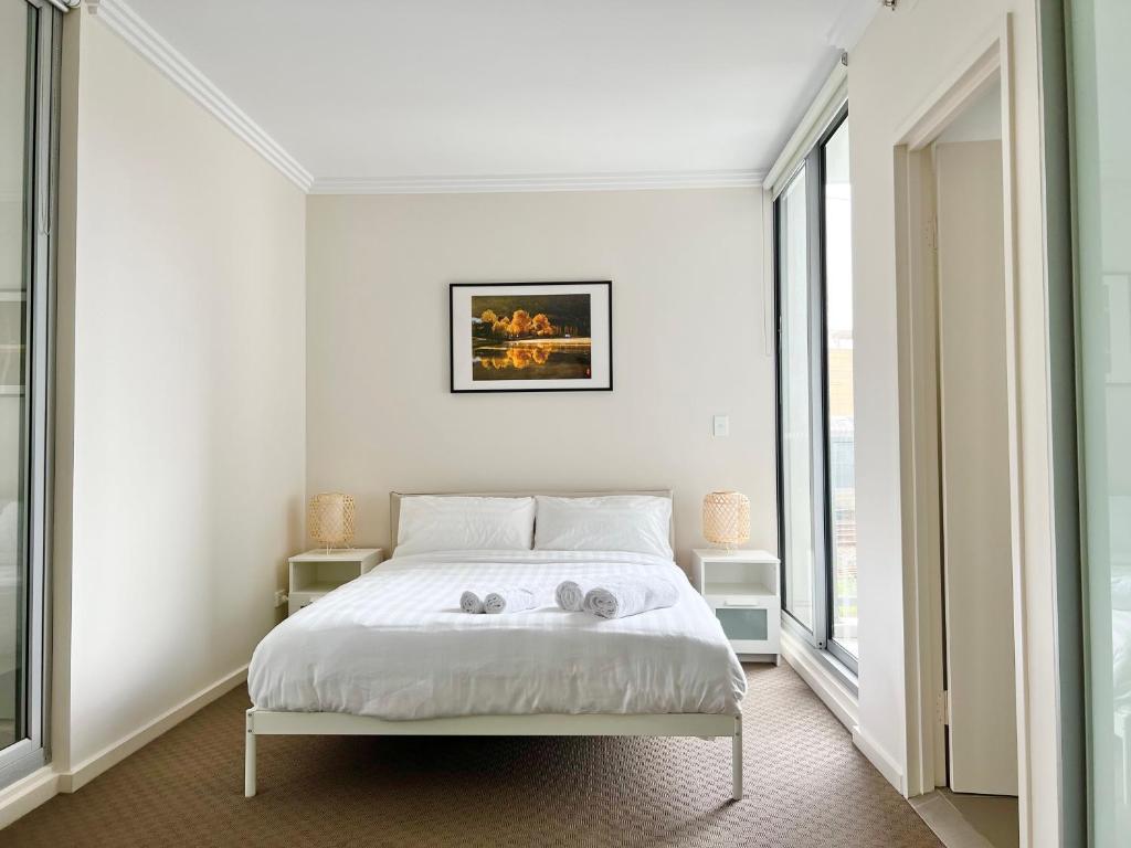 a bedroom with a bed with two towels on it at Charming One-Bed Apt in the Heart of Parramatta in Sydney