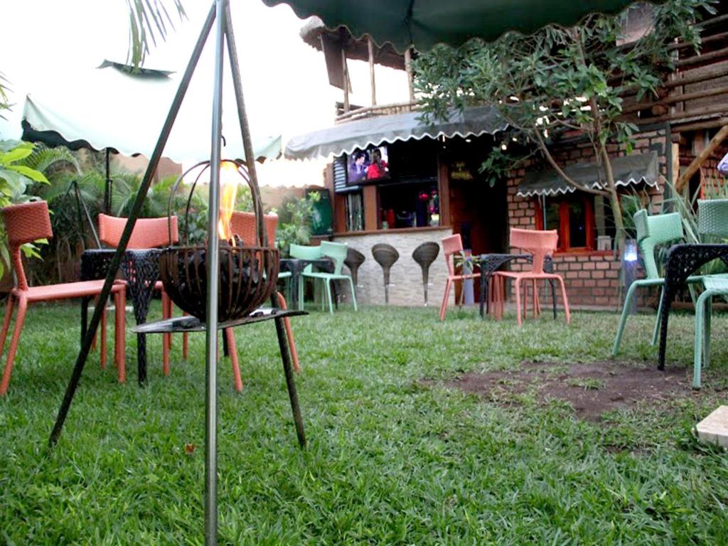 eine Gruppe von Stühlen und Tischen in einem Hof in der Unterkunft Hotel Gorilla's Nest Entebbe in Kitende