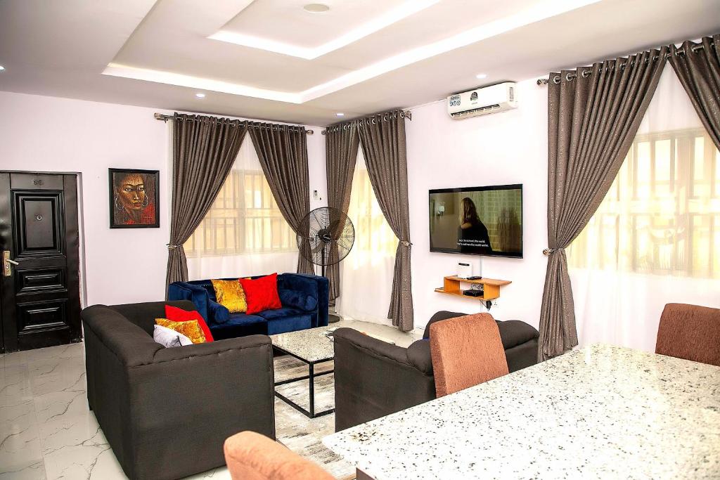 uma sala de estar com um sofá e uma mesa em ARO APARTMENTS: (College Road) em Lagos