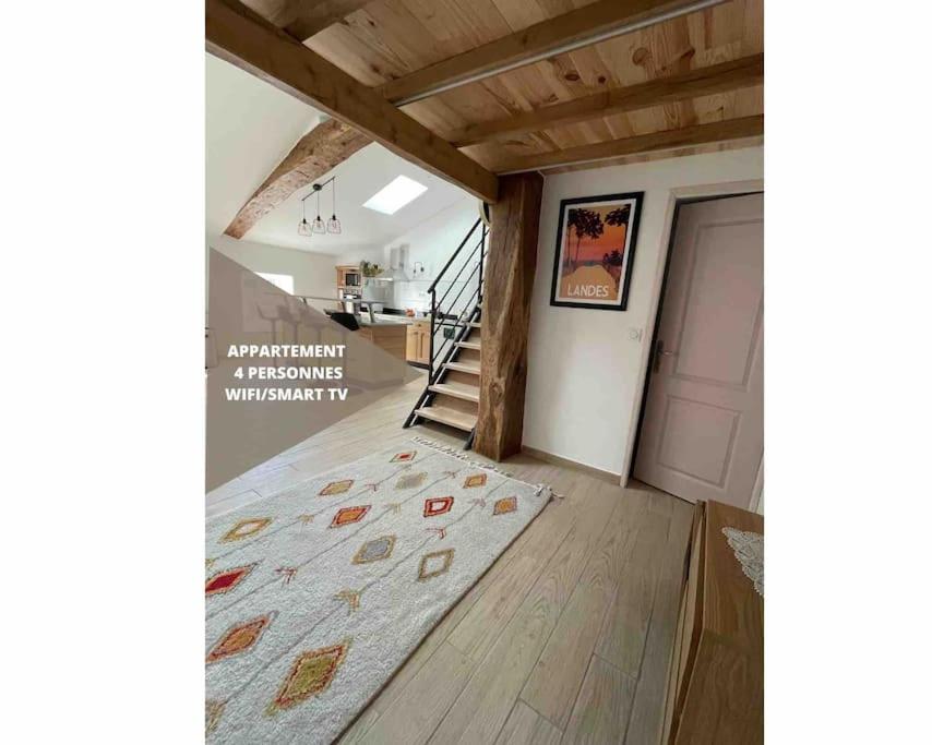 sala de estar con escalera y alfombra en el suelo en Le nid de bois - Centre ville - WIFI/SMART TV, en Casteljaloux