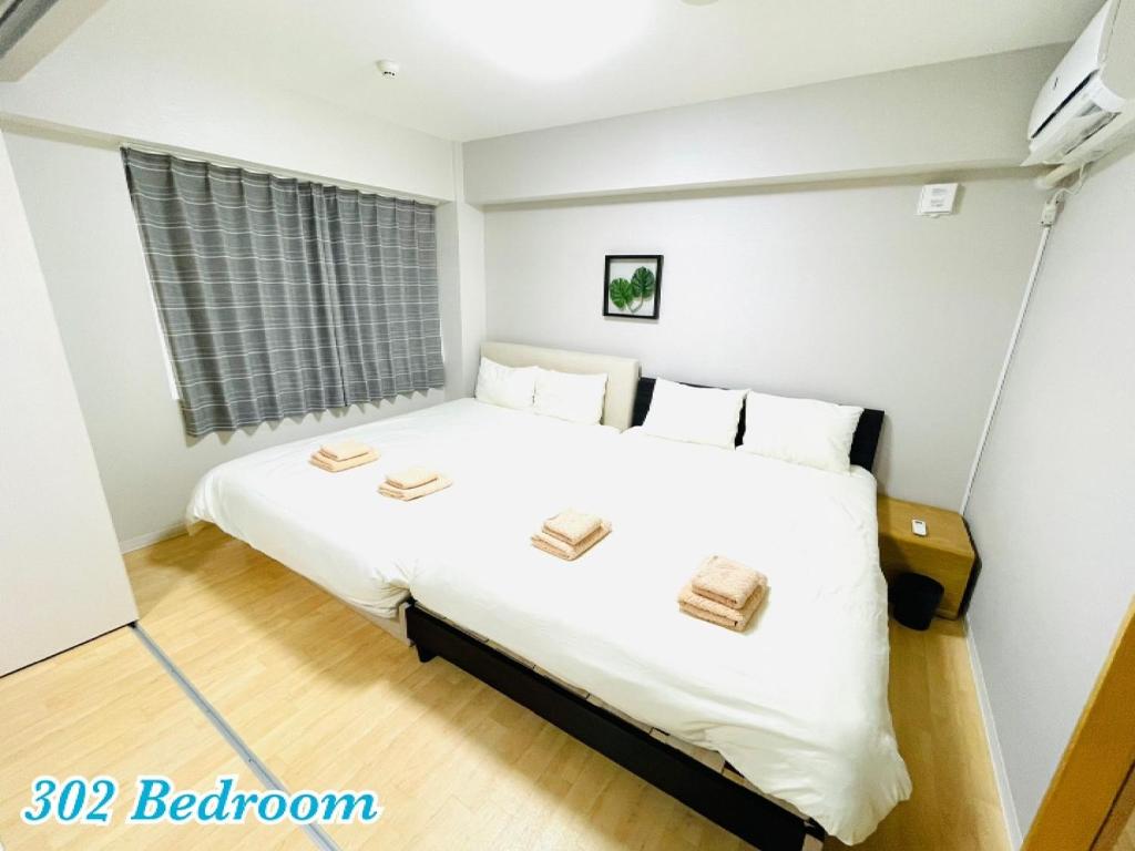 um quarto com uma grande cama branca com dois livros em Mcity in WAKASA - Vacation STAY 84253v em Naha