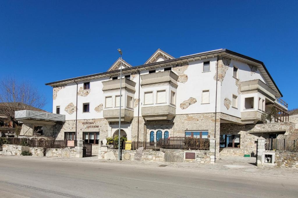 un grand bâtiment blanc sur le côté d'une rue dans l'établissement Domus Romulea, à Bisaccia