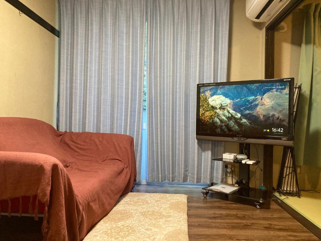 ein Wohnzimmer mit einem TV und einem Sofa in der Unterkunft ARASHIMA INN 203 / Vacation STAY 230 in Toba