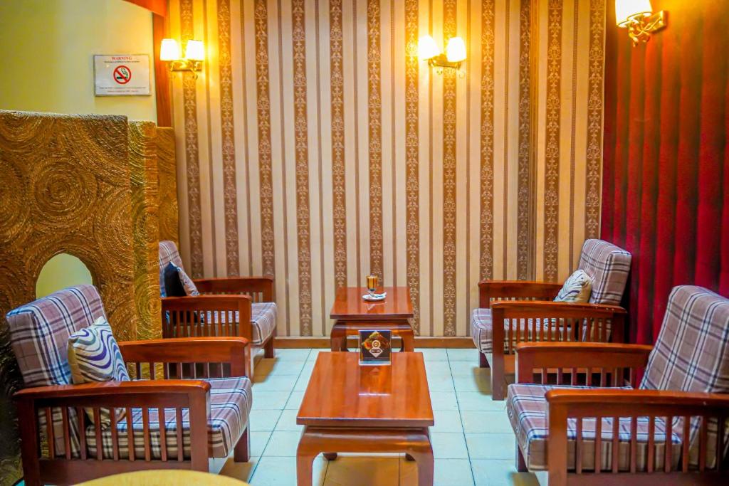 a waiting room with chairs and tables and a wall at After 40 Hotel in Nairobi
