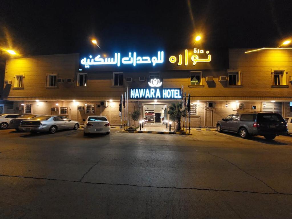hotel kaanala w nocy z samochodami zaparkowanymi na parkingu w obiekcie Nawara Apartments 24 w Rijadzie
