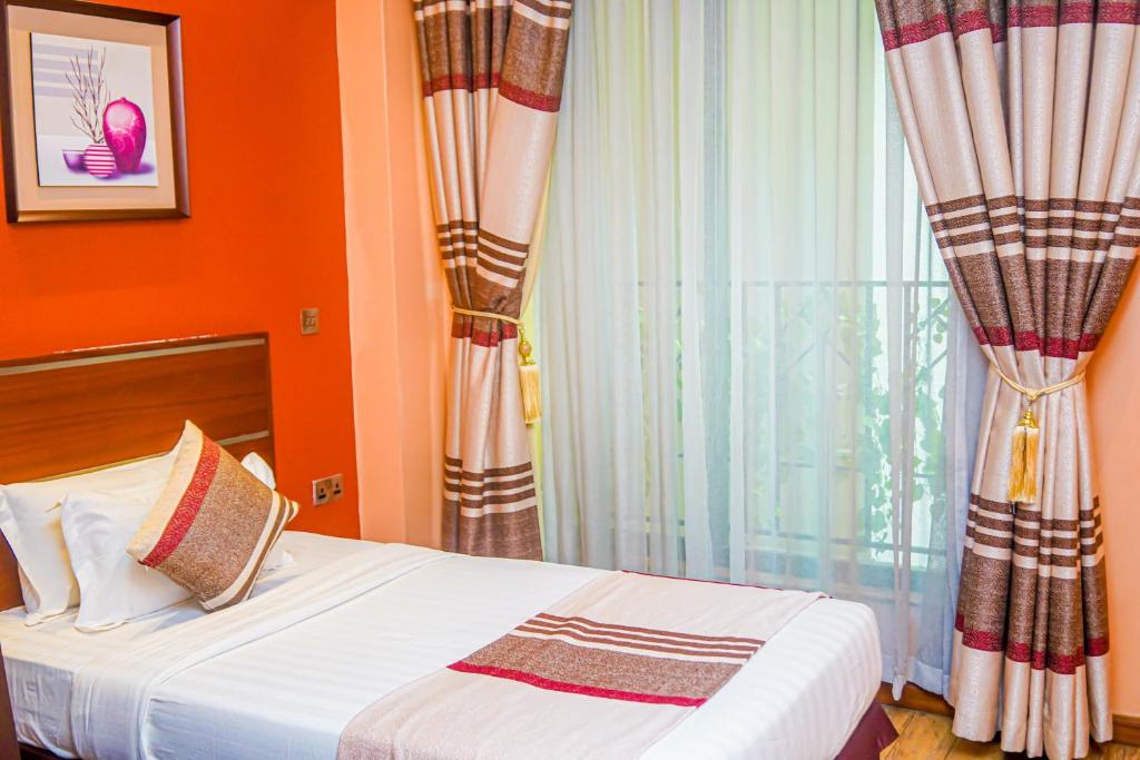 a hotel room with a bed and a window at After 40 Hotel in Nairobi