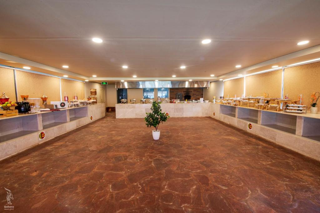 a large empty room with a potted plant in the middle at Sahary Al Ula Resort in AlUla