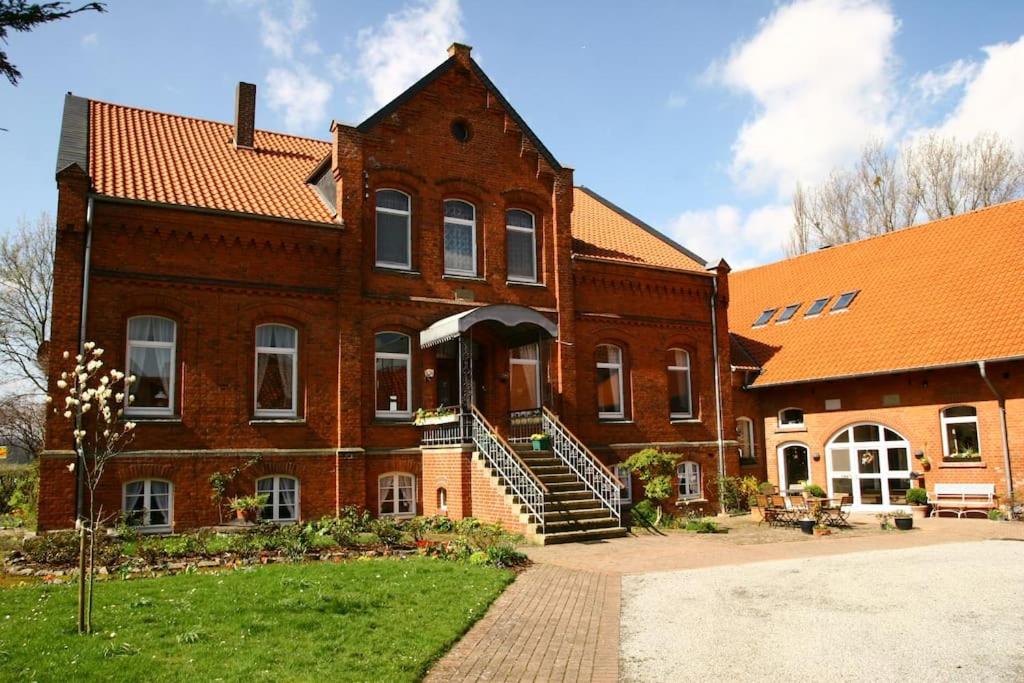 a large brick building with a staircase in front of it at Idyllische Ferienwohnung auf altem Bauernhof in Emmerthal