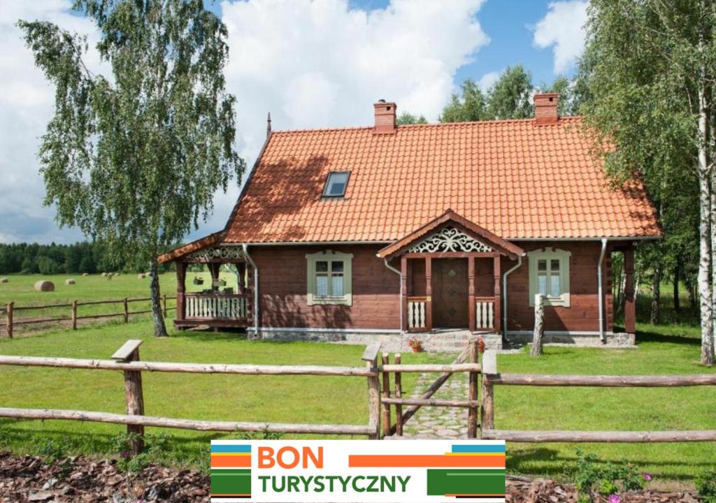 a small house in a field with a fence at MAZURY chillout in Ryn