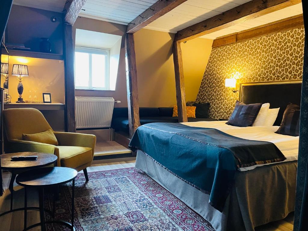 オーフスにあるÅhus Gästgivaregårdのベッドと椅子付きのホテルルーム