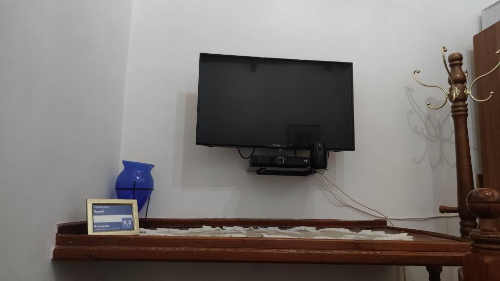a flat screen tv hanging on a wall with a table at Dameli in Sykaminéa
