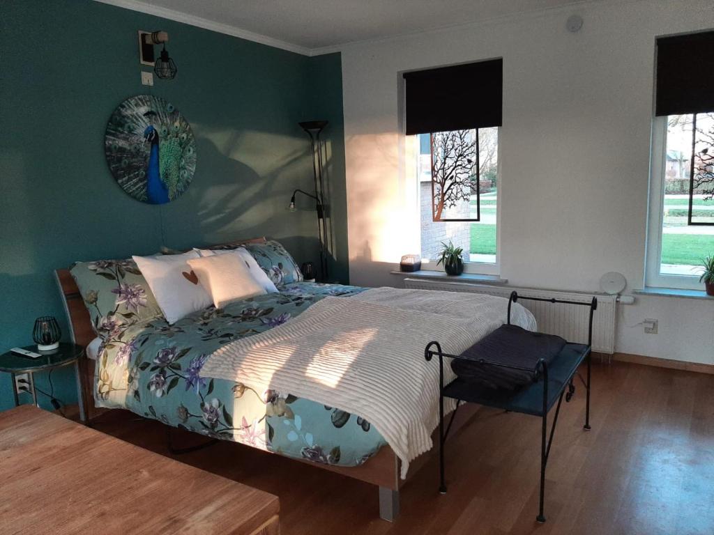 a bedroom with a bed and a table and windows at Grutsk op 12 in Drachten