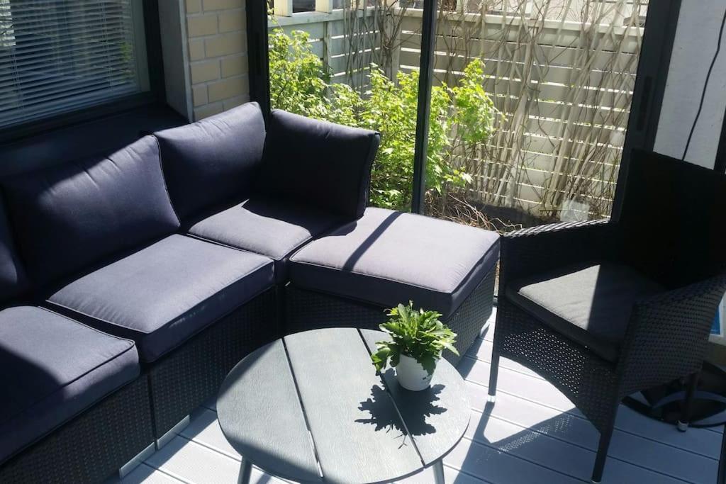 a patio with two chairs and a couch and a table at Spacious super located Lahti apartment in Lahti