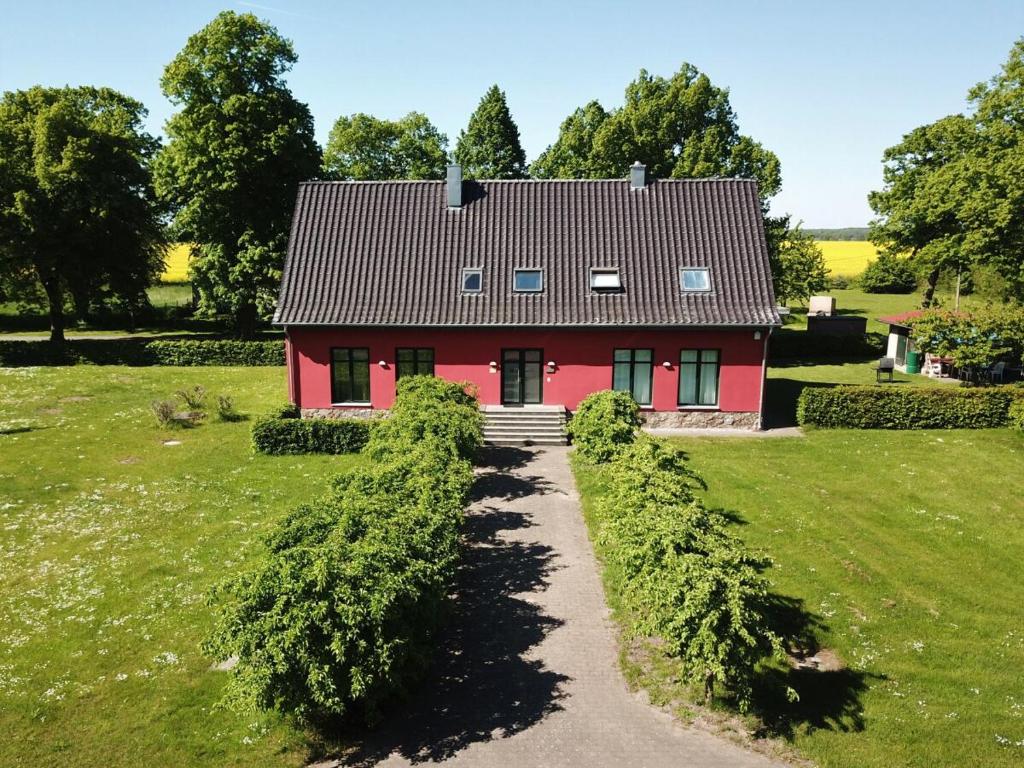 una casa roja en medio de un campo en Ferienwohnung auf Gut Owstin, en Owstin