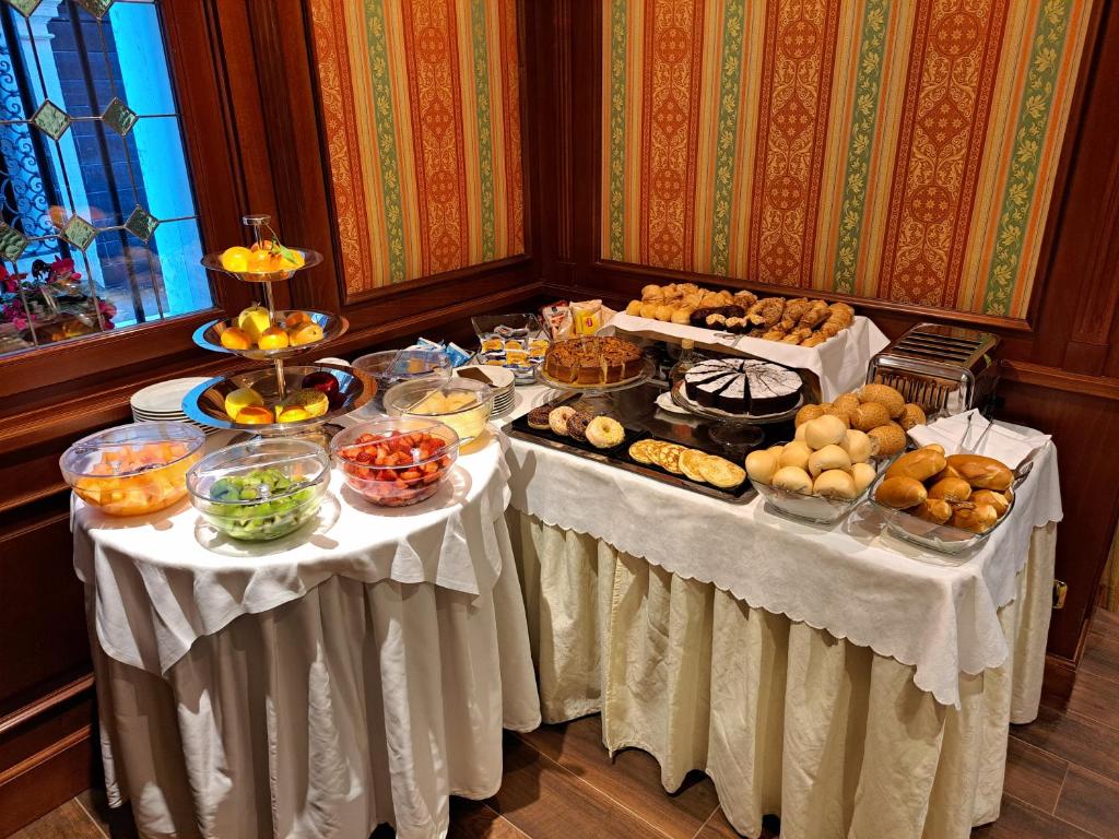 a buffet with two tables with food on them at Sina Palazzo Sant'Angelo in Venice
