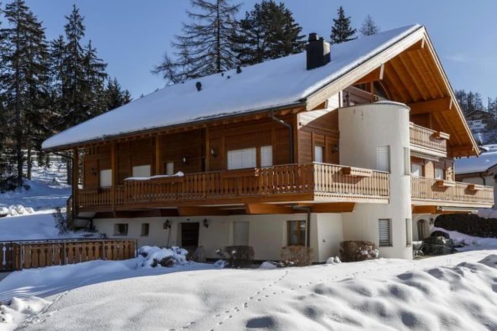 Cette grande maison en bois dispose d'un balcon dans la neige. dans l'établissement Best view in Crans-Montana, à Crans-Montana