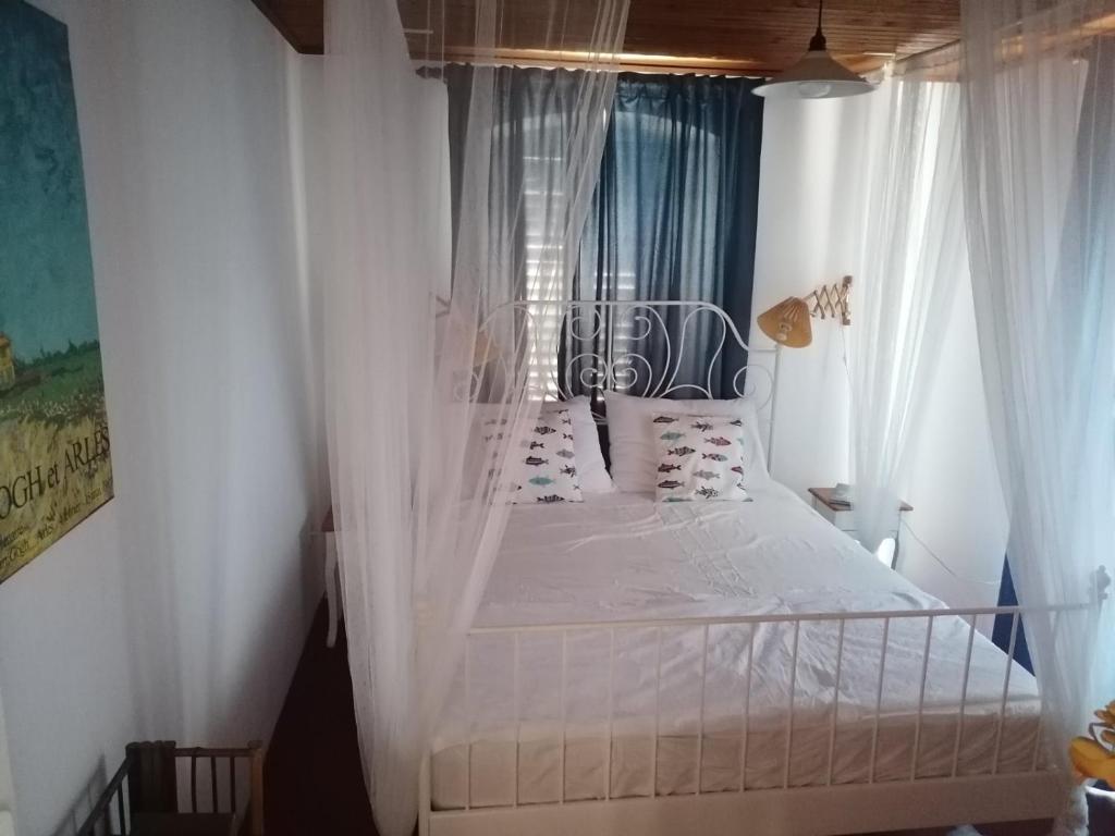 Schlafzimmer mit Himmelbett und weißen Vorhängen in der Unterkunft Two-bedroom apartment with sea view in Stari Grad