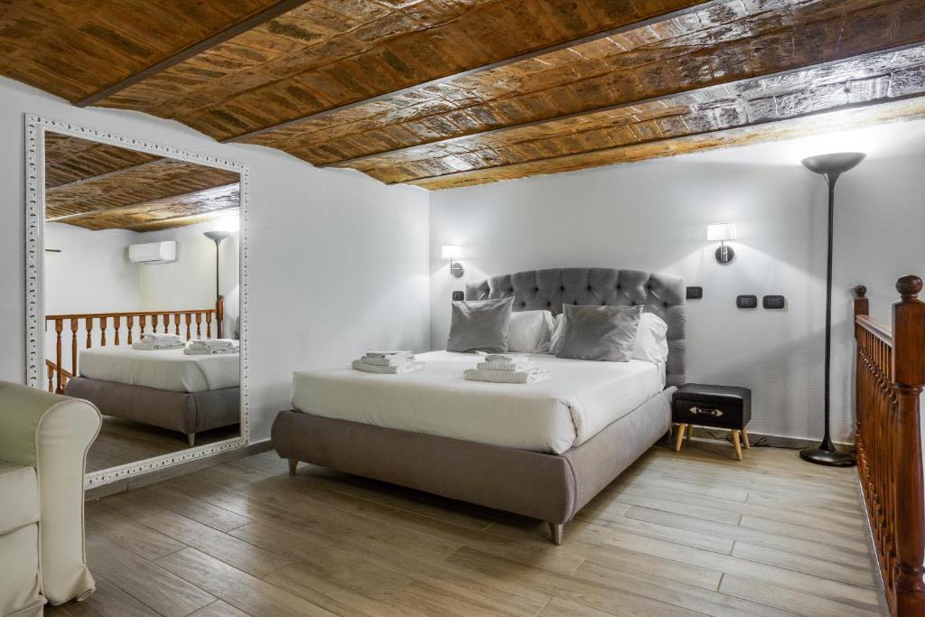 een slaapkamer met een groot bed en een spiegel bij Operà Suites Pinciana in Rome