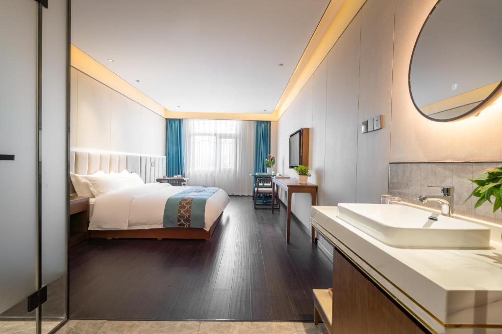 a hotel bathroom with a bed and a sink at Chinese Culture Holiday Hotel - Nanluoguxiang in Beijing