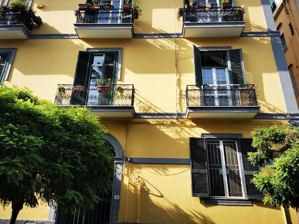 um edifício amarelo com janelas e varandas pretas em residenza San Martino em Nápoles