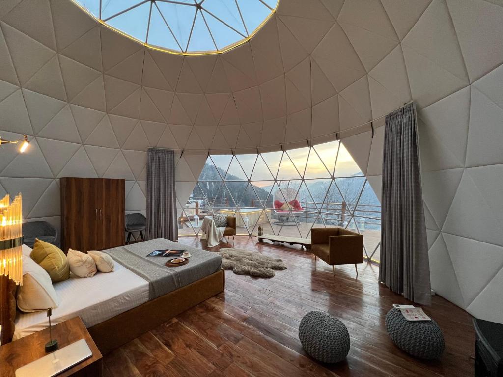 - une chambre avec un lit et un grand plafond en verre dans l'établissement GLAMPING CLUB, à Manali