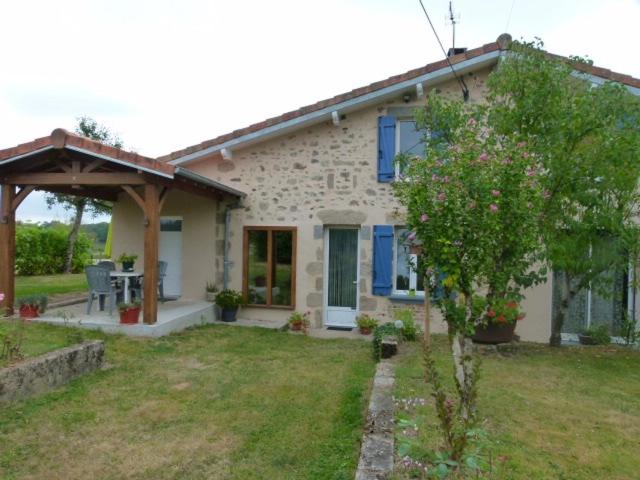 uma casa de pedra com um pátio e uma árvore em Lumineuse maison de vacances avec jardin clos em Bussière-Boffy