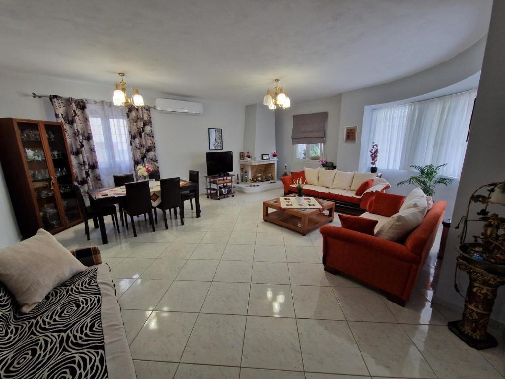 a living room with couches and a dining room at LiriKa's airport house in Artemida