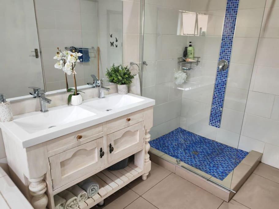 a bathroom with a white sink and a shower at Entire 4 bedroom house in Midrand, Johannesburg in Randjesfontein