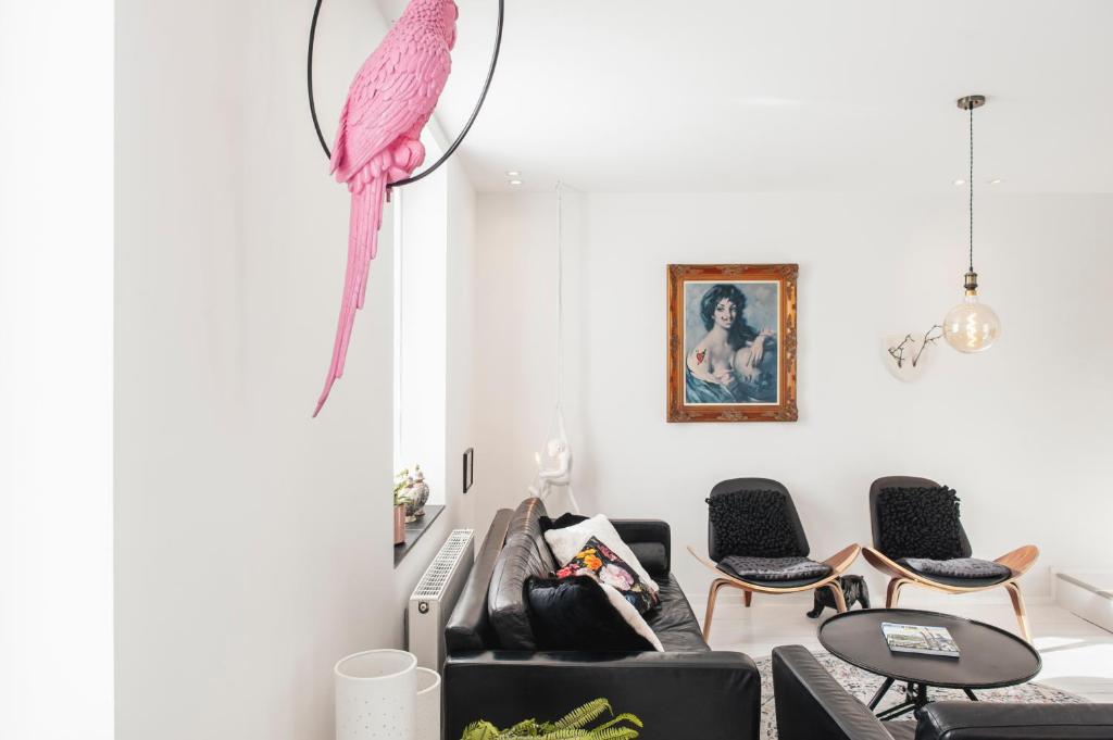 a pink parrot hanging from a wall in a living room at Vakantiehuis Juliette in Diksmuide