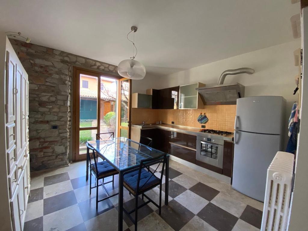 a kitchen with a glass table and a refrigerator at Gioco in San Vincenzo