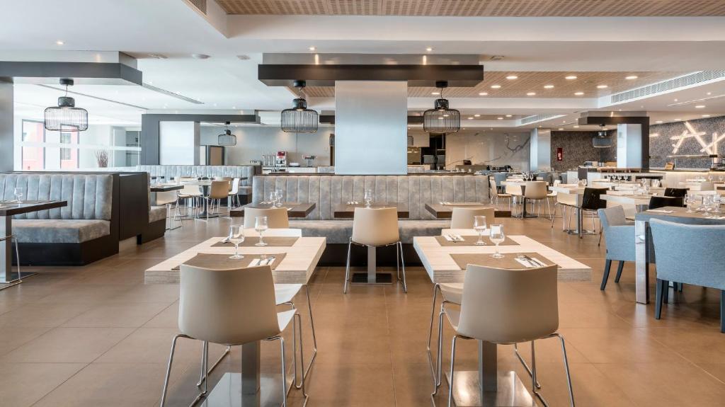 a restaurant with tables and chairs and a bar at Ilunion Calas de Conil in Conil de la Frontera