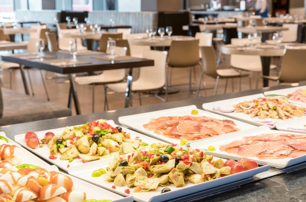 a table with several plates of food on it at Ilunion Calas de Conil in Conil de la Frontera