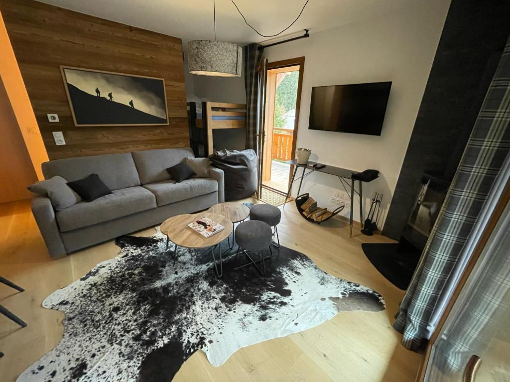 a living room with a couch and a table at Alpine Creek Chalet Luxury Ski-in in Morzine
