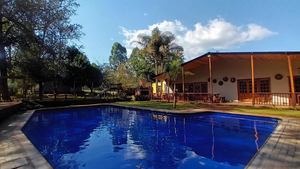 a blue swimming pool in front of a house at Eagle Creek Resorts Sabie in Sabie