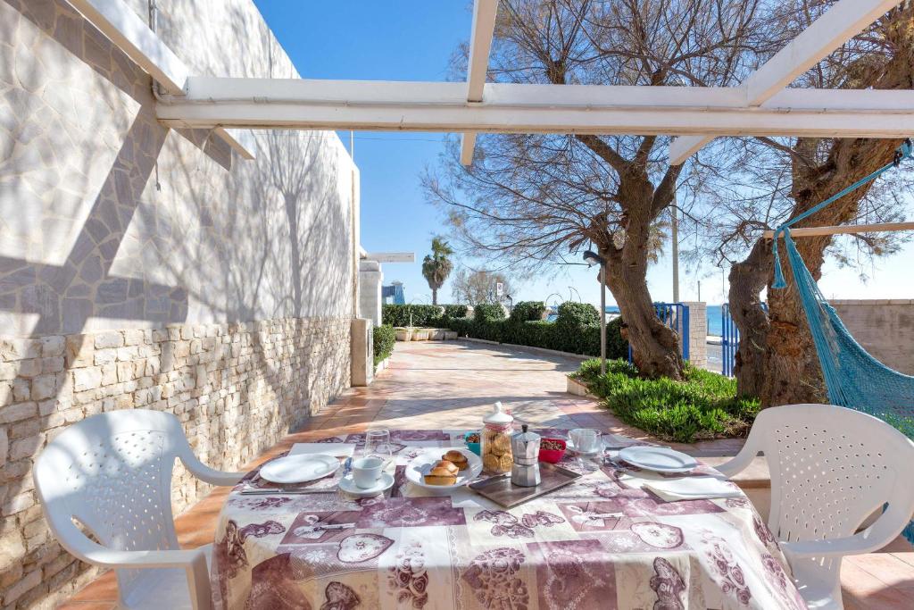 un tavolo con un piatto di cibo seduto su un patio di Residence La Scogliera by BarbarHouse a Torre Colimena