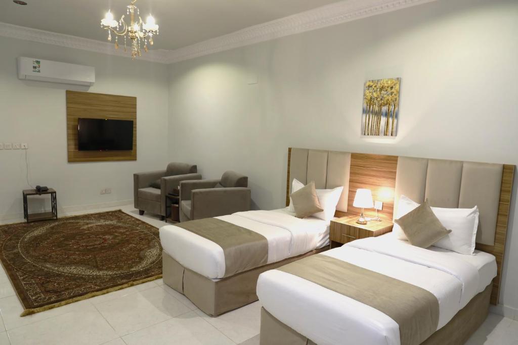 Habitación de hotel con 2 camas y sofá en وردة رومه للوحدات السكنية en Medina