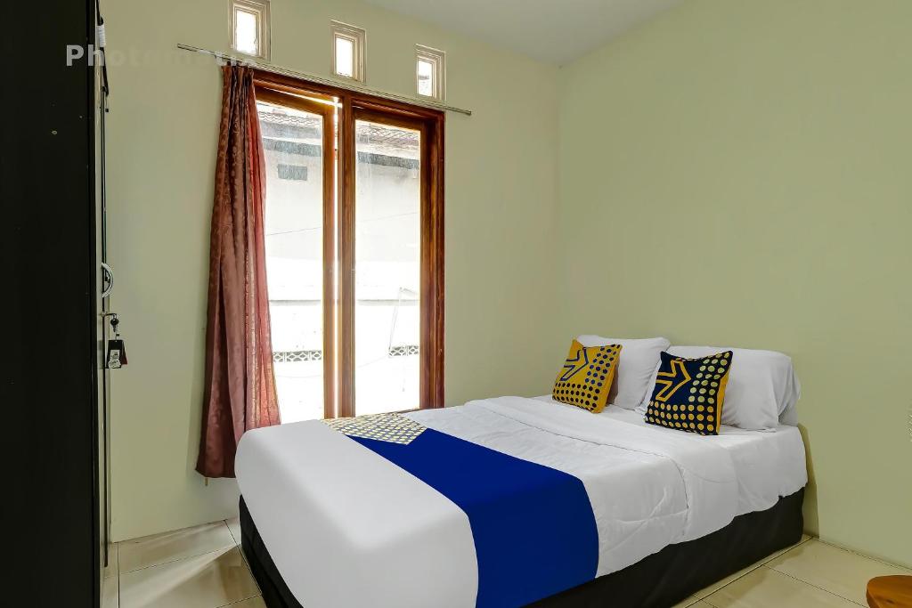 a bed in a room with a window at OYO Life 92258 Kostel 21 Syariah in Semarang