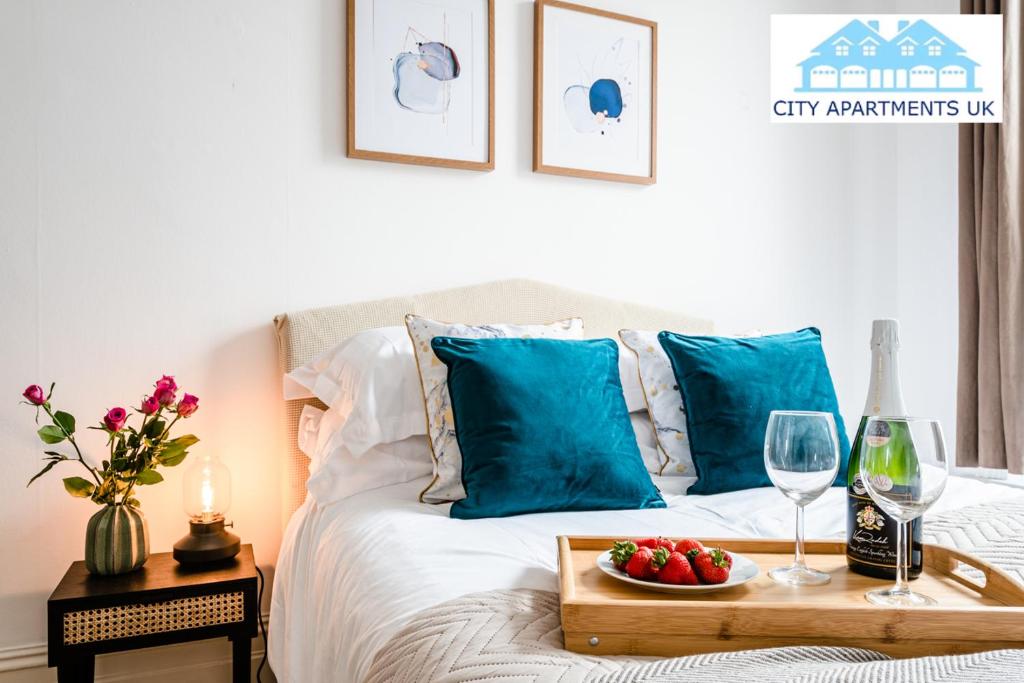 1 cama con bandeja de fruta y copas de vino en Charming 1 Bed Apt in Kensington - Free London Tour Included By City Apartments UK Short Lets Serviced Accommodation, en Londres