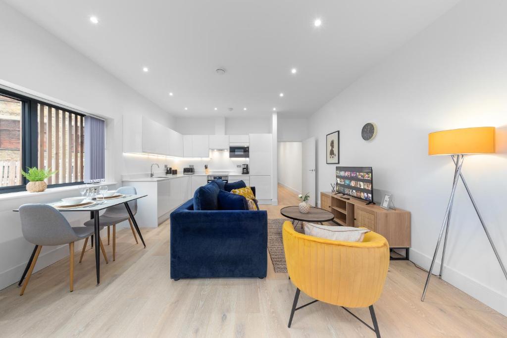 uma sala de estar com um sofá azul e uma mesa em SERCASA - Appletree Court - Kingston em Kingston upon Thames