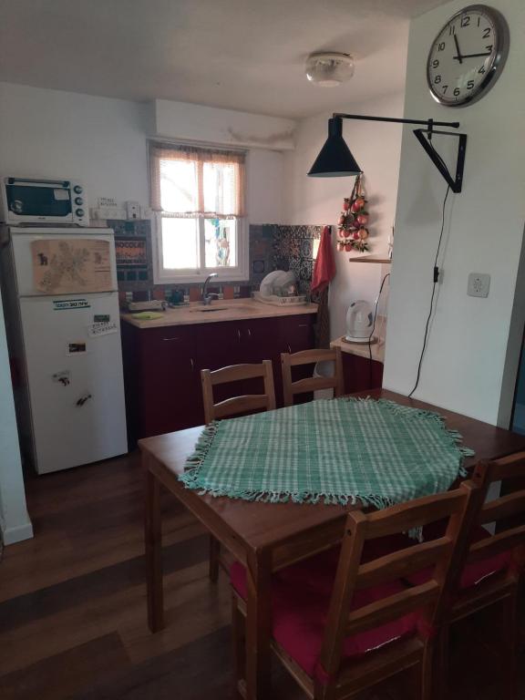 uma cozinha com uma mesa de madeira e uma cozinha com um relógio em הבית הירוק - Green House em Arad