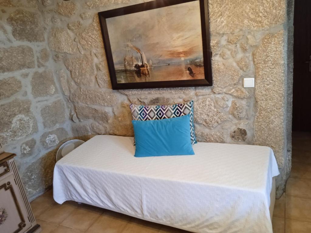 a room with a bed in a stone wall at Casa da Massada in Belmonte
