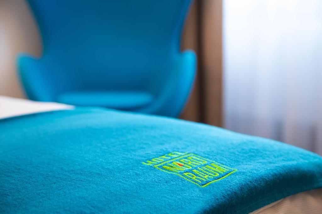 a blue pillow with a sign on top of it at Hotel NordRaum in Bremen